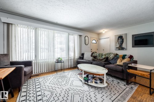 Living room featuring light wood finished floors and a textured ceiling - 12231 47 Street, Edmonton, AB - Indoor Photo Showing Living Room
