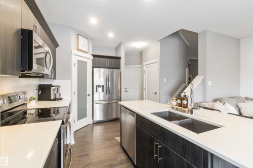 Kitchen featuring stainless steel appliances, dark wood-type flooring, open floor plan, light stone countertops, and recessed lighting - 17143 38 Street, Edmonton, AB - Indoor Photo Showing Kitchen With Double Sink With Upgraded Kitchen
