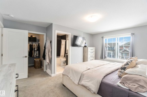 Bedroom featuring a walk in closet, light carpet, and connected bathroom - 17143 38 Street, Edmonton, AB - Indoor Photo Showing Bedroom