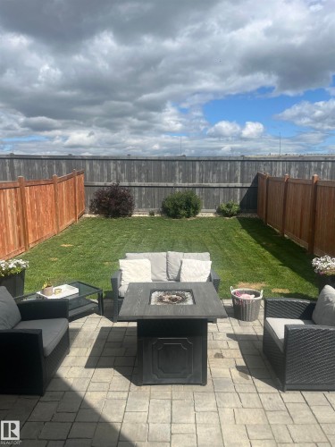 Fenced backyard featuring an outdoor living space with a fire pit and a patio area - 17143 38 Street, Edmonton, AB - Outdoor