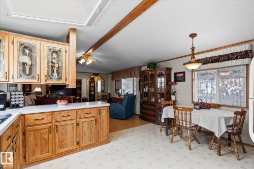 Kitchen with glass fronted cabinets, light countertops, light flooring, a peninsula, and arched walkways - 89-3400 48, Stony Plain, AB - Indoor