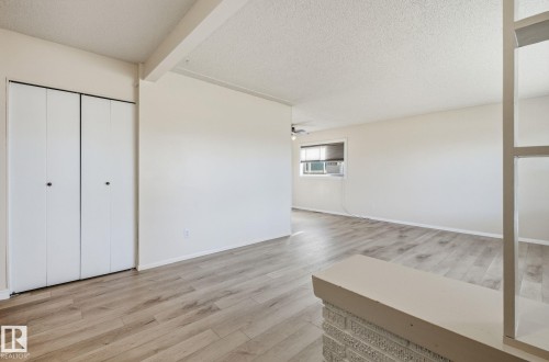 Basement with a textured ceiling and light wood-style floors - 12107 53 Street, Edmonton, AB - Indoor Photo Showing Other Room