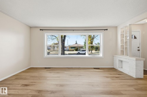 Spare room with light wood finished floors and a textured ceiling - 12107 53 Street, Edmonton, AB - Indoor Photo Showing Other Room