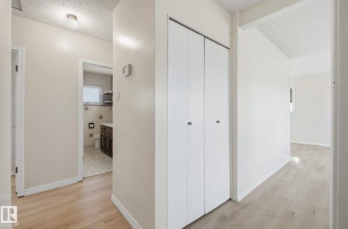 Hall with a textured ceiling and light wood-style flooring - 12107 53 Street, Edmonton, AB - Indoor Photo Showing Other Room
