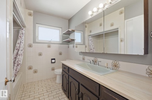 Bathroom featuring vanity, shower / bath combo with shower curtain, and light tile patterned floors - 12107 53 Street, Edmonton, AB - Indoor Photo Showing Bathroom