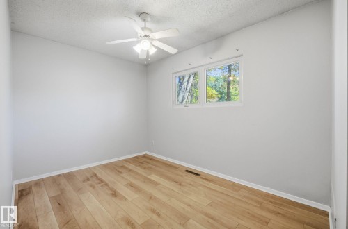 Spare room with light wood-style floors, a textured ceiling, and ceiling fan - 12107 53 Street, Edmonton, AB - Indoor Photo Showing Other Room