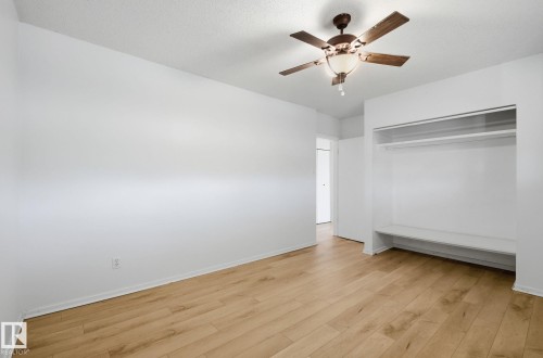 Unfurnished bedroom featuring a ceiling fan, light wood-type flooring, and a closet - 12107 53 Street, Edmonton, AB - Indoor Photo Showing Other Room