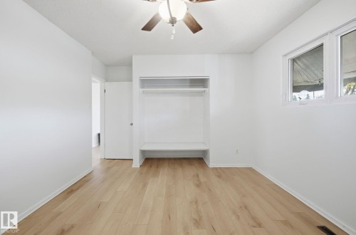Unfurnished bedroom featuring light wood-style floors, ceiling fan, and a closet - 12107 53 Street, Edmonton, AB - Indoor Photo Showing Other Room