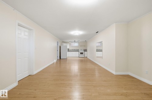 Unfurnished living room with light wood finished floors and crown molding - 12107 53 Street, Edmonton, AB - Indoor Photo Showing Other Room