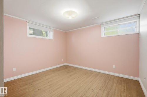 Basement with light wood-type flooring and crown molding - 12107 53 Street, Edmonton, AB - Indoor Photo Showing Other Room