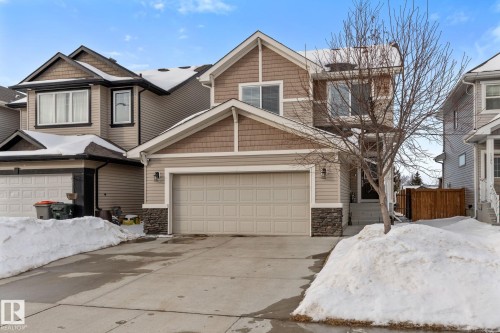 Craftsman-style house with stone siding, a garage, and driveway - 1043 South Creek Wynd, Stony Plain, AB - Outdoor With Facade