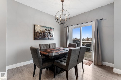Dining area with light wood finished floors and suspended lighting - 1043 South Creek Wynd, Stony Plain, AB - Indoor Photo Showing Dining Room