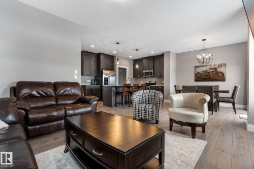 Living room with hanging lights and light wood-style flooring - 1043 South Creek Wynd, Stony Plain, AB - Indoor Photo Showing Living Room