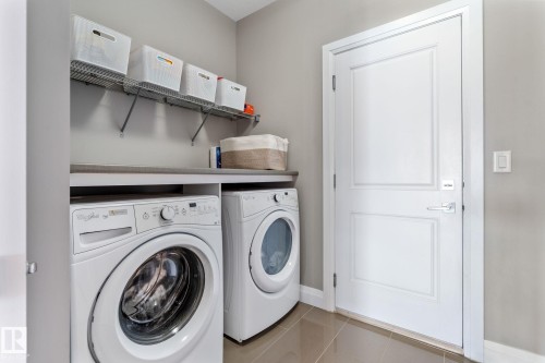 Laundry room with light tile patterned floors and washer and dryer - 1043 South Creek Wynd, Stony Plain, AB - Indoor Photo Showing Laundry Room