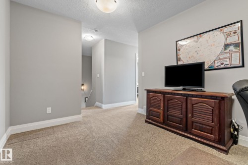 Living room with light carpet and a textured ceiling - 1043 South Creek Wynd, Stony Plain, AB - Indoor