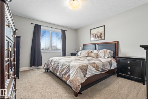 Bedroom featuring light carpet and a textured ceiling - 1043 South Creek Wynd, Stony Plain, AB - Indoor Photo Showing Bedroom
