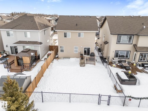 Snow covered property with a gazebo, a fenced backyard, a gate, a deck, and a residential view - 1043 South Creek Wynd, Stony Plain, AB - Outdoor