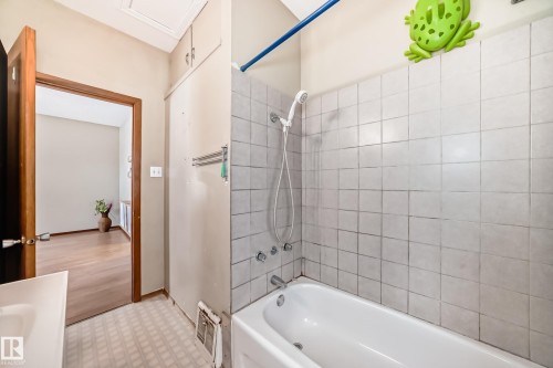 Bathroom featuring bathing tub / shower combination, light flooring, and vanity - 9823 75 Avenue, Edmonton, AB - Indoor Photo Showing Bathroom