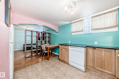 Kitchen featuring white appliances, dark countertops, light wood finish cabinetry, and a desk - 9823 75 Avenue, Edmonton, AB - Indoor Photo Showing Other Room