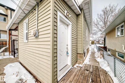 Snow covered property entrance featuring a deck - 9823 75 Avenue, Edmonton, AB - Outdoor