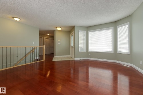 Unfurnished living room featuring wood finished floors and a textured ceiling - 9916 178 Avenue, Edmonton, AB - Indoor Photo Showing Other Room