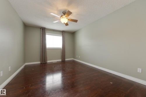 Unfurnished room with dark wood-style flooring, a textured ceiling, and ceiling fan - 9916 178 Avenue, Edmonton, AB - Indoor Photo Showing Other Room