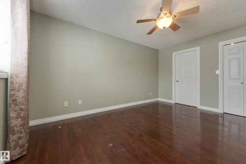 Unfurnished bedroom with dark wood-style flooring, a textured ceiling, and ceiling fan - 9916 178 Avenue, Edmonton, AB - Indoor Photo Showing Other Room