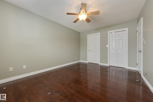 Unfurnished bedroom featuring dark wood finished floors, ceiling fan, a textured ceiling, and a closet - 9916 178 Avenue, Edmonton, AB - Indoor Photo Showing Other Room