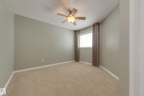 Unfurnished room featuring a textured ceiling, light carpet, and ceiling fan - 9916 178 Avenue, Edmonton, AB - Indoor Photo Showing Other Room