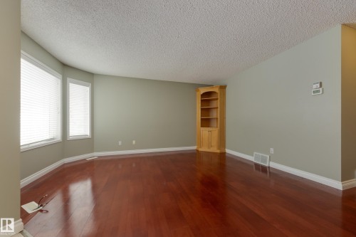 Empty room with dark wood-style floors and a textured ceiling - 9916 178 Avenue, Edmonton, AB - Indoor Photo Showing Other Room