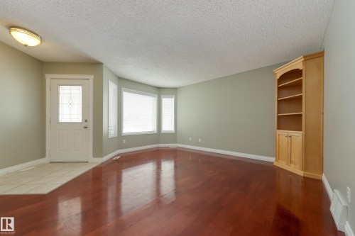 Entrance foyer featuring a textured ceiling and dark wood-style floors - 9916 178 Avenue, Edmonton, AB - Indoor Photo Showing Other Room