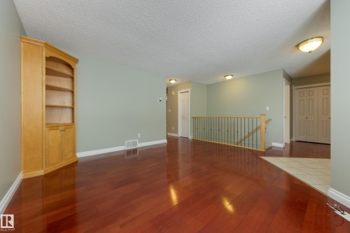 Empty room with dark wood-style floors and a textured ceiling - 9916 178 Avenue, Edmonton, AB - Indoor Photo Showing Other Room