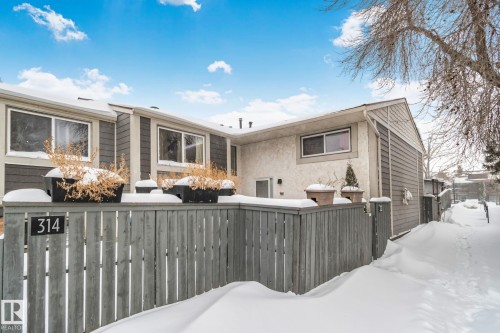 Snow covered house featuring a fenced front yard and stucco siding - 313 Willow Court, Edmonton, AB - Outdoor
