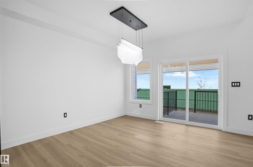 Unfurnished dining area with baseboards and light wood-style flooring - 15415 20 Street, Edmonton, AB - Indoor Photo Showing Other Room