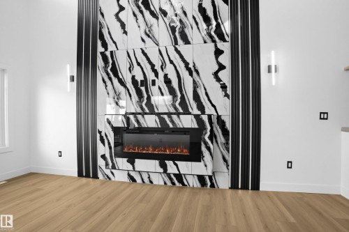Detailed view of a premium fireplace and wood finished floors - 15415 20 Street, Edmonton, AB - Indoor Photo Showing Other Room With Fireplace