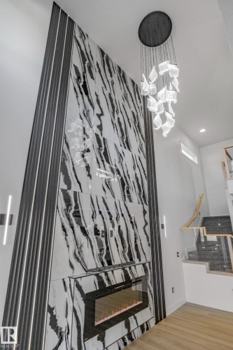Stairway with a fireplace, wood finished floors, and recessed lighting - 15415 20 Street, Edmonton, AB - Indoor