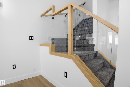 Staircase with baseboards and wood finished floors - 15415 20 Street, Edmonton, AB - Indoor Photo Showing Other Room