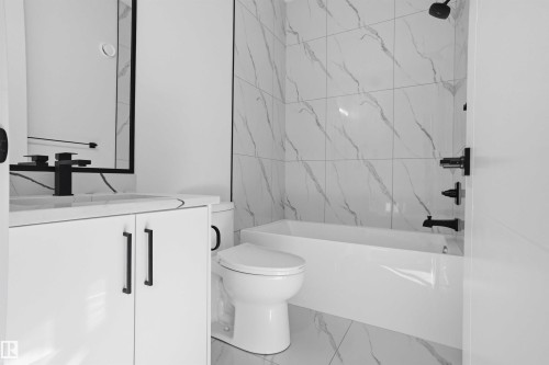 Full bathroom with vanity, marble look tile flooring, and shower / washtub combination - 15415 20 Street, Edmonton, AB - Indoor Photo Showing Bathroom