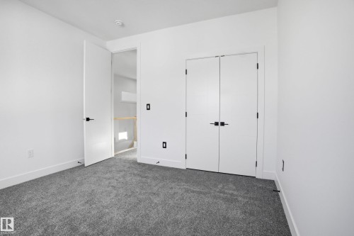 Unfurnished bedroom with dark carpet and a closet - 15415 20 Street, Edmonton, AB - Indoor Photo Showing Other Room