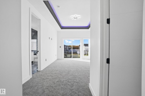 Hallway featuring a tray ceiling and carpet floors - 15415 20 Street, Edmonton, AB - Indoor Photo Showing Other Room