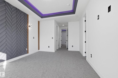 Unfurnished bedroom featuring light carpet and a tray ceiling - 15415 20 Street, Edmonton, AB - Indoor Photo Showing Other Room