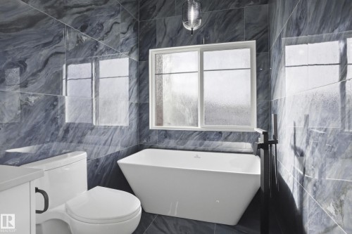 Full bathroom with tile walls, a freestanding tub, and vanity - 15415 20 Street, Edmonton, AB - Indoor Photo Showing Bathroom