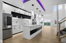 Kitchen featuring white cabinetry, stainless steel appliances, an island with sink, hanging light fixtures, and a high ceiling - 15415 20 Street, Edmonton, AB  - Indoor Photo Showing Kitchen With Upgraded Kitchen 