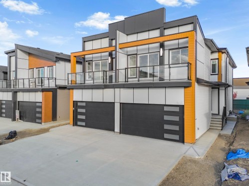 View of front of property featuring a garage, driveway, and board and batten siding - 15415 20 Street, Edmonton, AB - Outdoor With Balcony