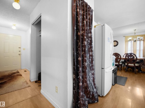 Hall with light wood finished floors, a textured ceiling, and suspended lighting - 17122 96 Street, Edmonton, AB - Indoor Photo Showing Other Room