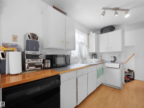 Kitchen featuring black appliances, white cabinets, light countertops, and light wood-style flooring - 17122 96 Street, Edmonton, AB - Indoor Photo Showing Kitchen