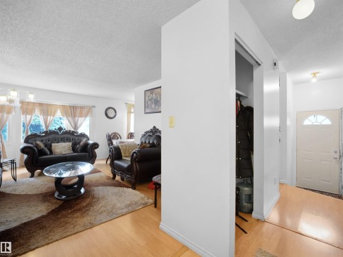 Living area with a textured ceiling and light wood-style floors - 17122 96 Street, Edmonton, AB - Indoor Photo Showing Other Room