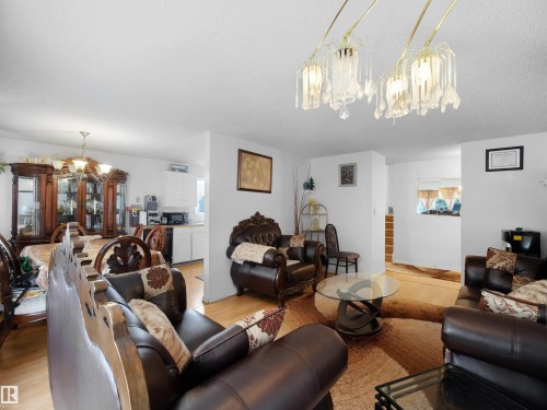 Living room with a chandelier, light wood-style floors, and a textured ceiling - 17122 96 Street, Edmonton, AB - Indoor Photo Showing Living Room
