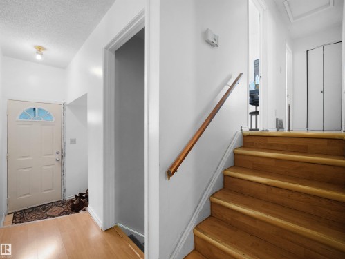 Stairway with a textured ceiling and wood finished floors - 17122 96 Street, Edmonton, AB - Indoor Photo Showing Other Room
