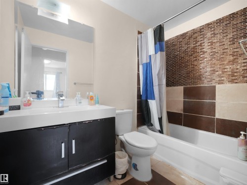Bathroom with vanity, tile patterned flooring, and shower / bath combo with shower curtain - 17122 96 Street, Edmonton, AB - Indoor Photo Showing Bathroom